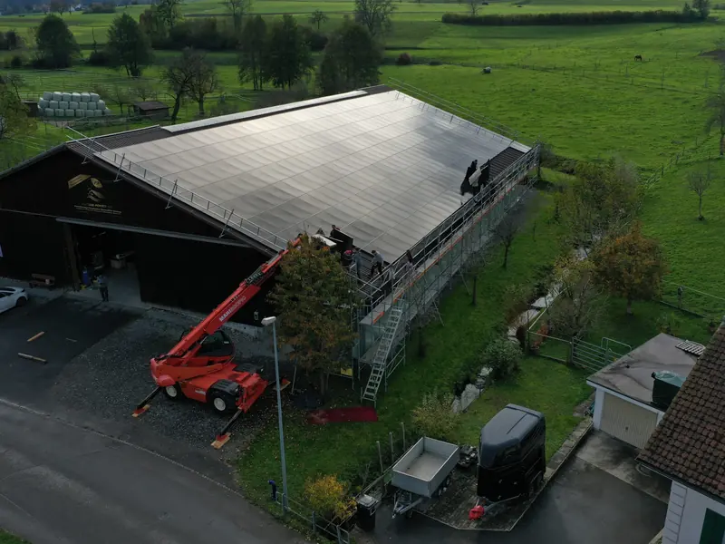 Luftaufnahme einer Photovoltaikanlage auf einem Gewerbebau mit Hebebühne