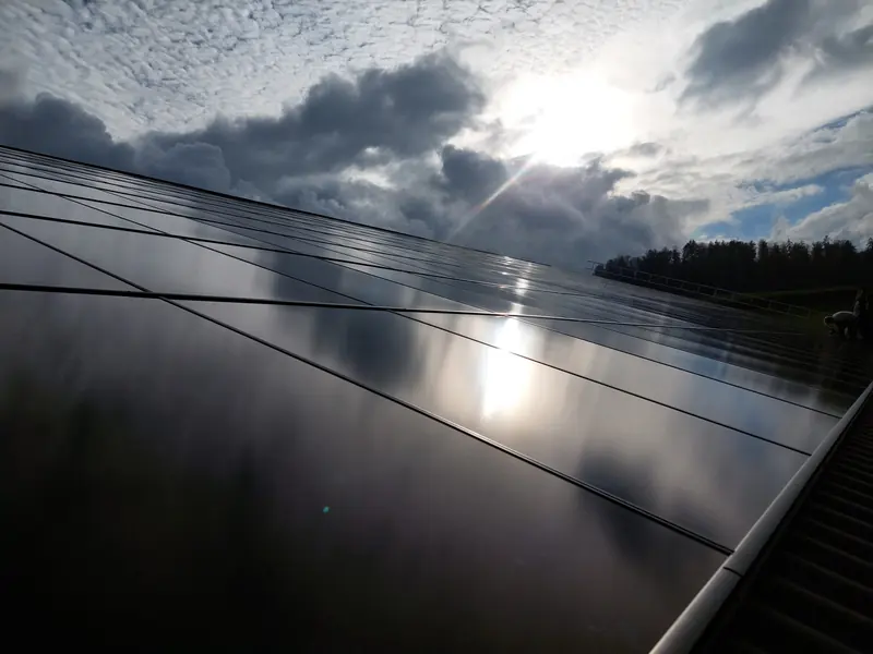 Schwarze Solarmodule einer Photovoltaikanlage im Gegenlicht der Sonne