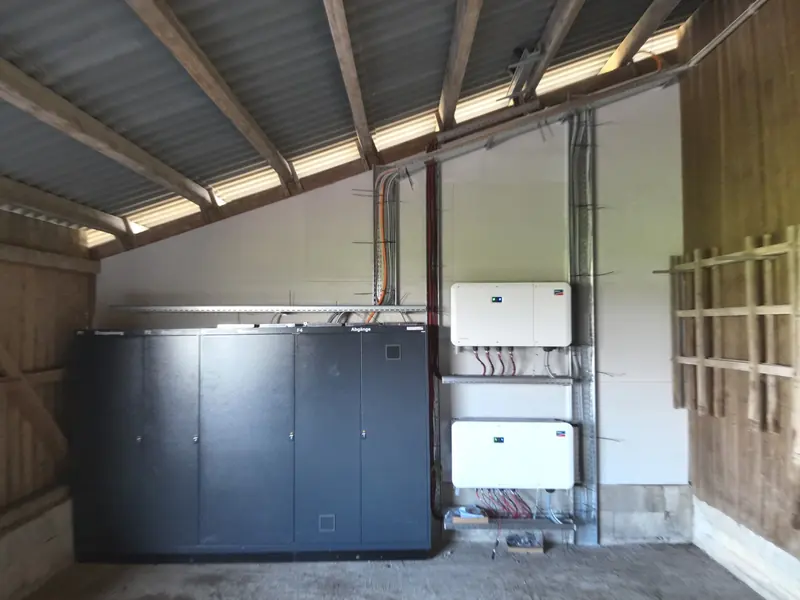 Batteriespeicher und Wechselrichter einer Photovoltaikanlage an der Wand eines Unterstands